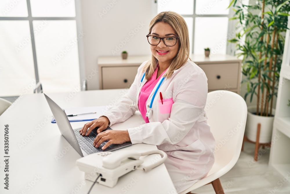 Young hispanic woman wearing doctor uniform working al clinic Young hispanic woman wearing doctor uniform working al clinic