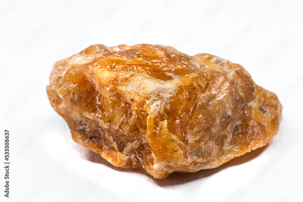 Raw orange calcite stone macro isolated on white background Raw orange calcite stone macro isolated on white background