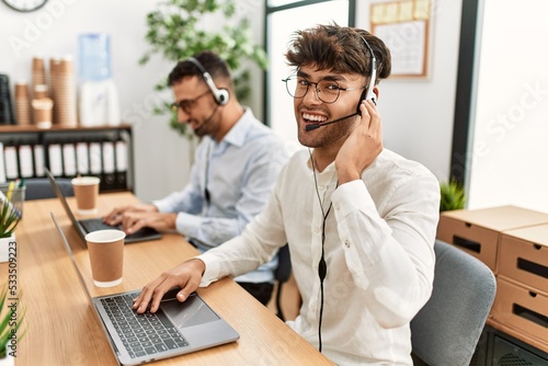 Two hispanic men call center agents smiling confident working at office