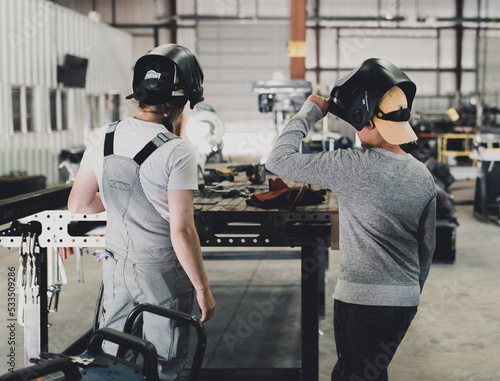 a female welder and student welder prepare to begin welding at the workshop photo