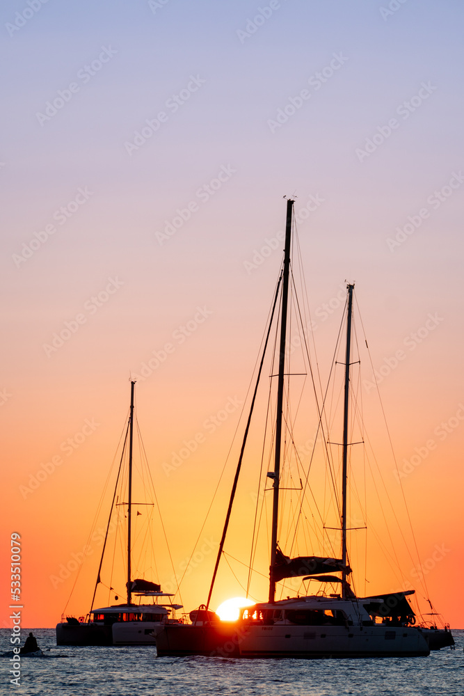 Two sailboats silhouetted by the sunset in the Mediterranean Sea