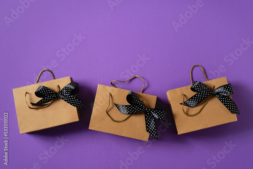 Gift box, package with black ribbon on purple background, black friday concept