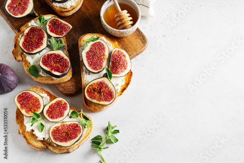 Fig bruschetta, bread and cream cheese and fruit on white background