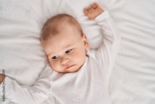 Adorable toddler lying on bed at bedroom