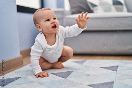 Adorable toddler crowling on floor at home photo