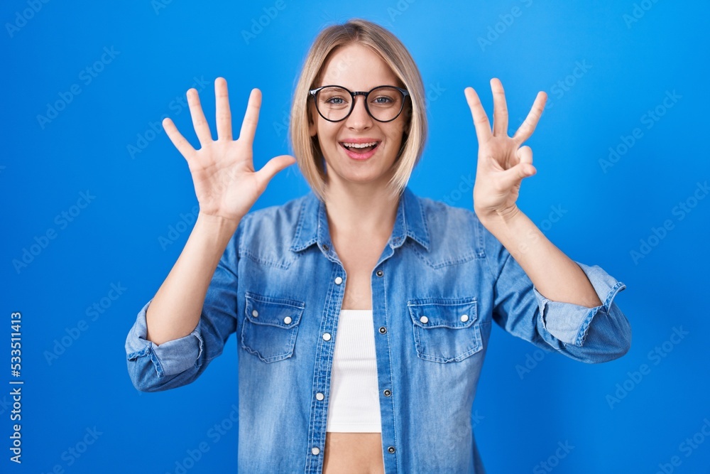 Young caucasian woman standing over blue background showing and pointing up with fingers number eight while smiling confident and happy. Young caucasian woman standing over blue background showing and pointing up with fingers number eight while smiling confident and happy.