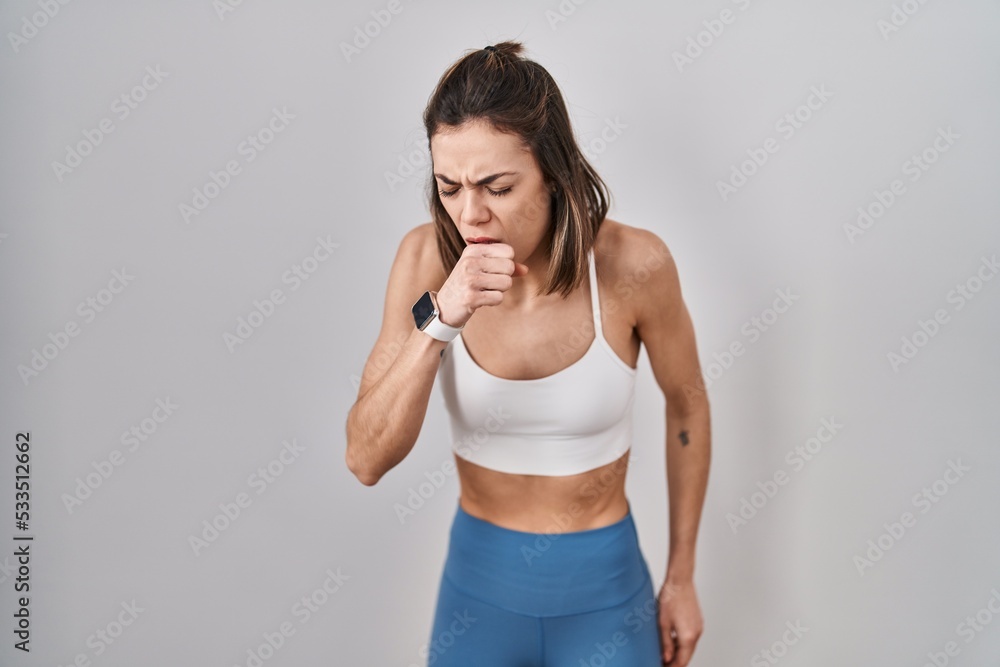 Hispanic woman wearing sportswear over isolated background feeling unwell and coughing as symptom for cold or bronchitis. health care concept.