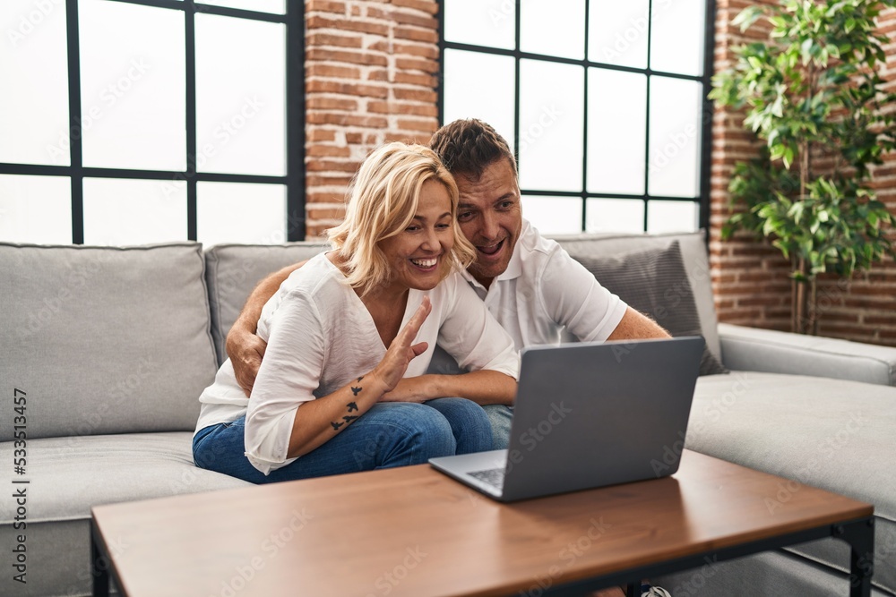 Middle age man and woman having video call sitting on sofa at home Middle age man and woman having video call sitting on sofa at home