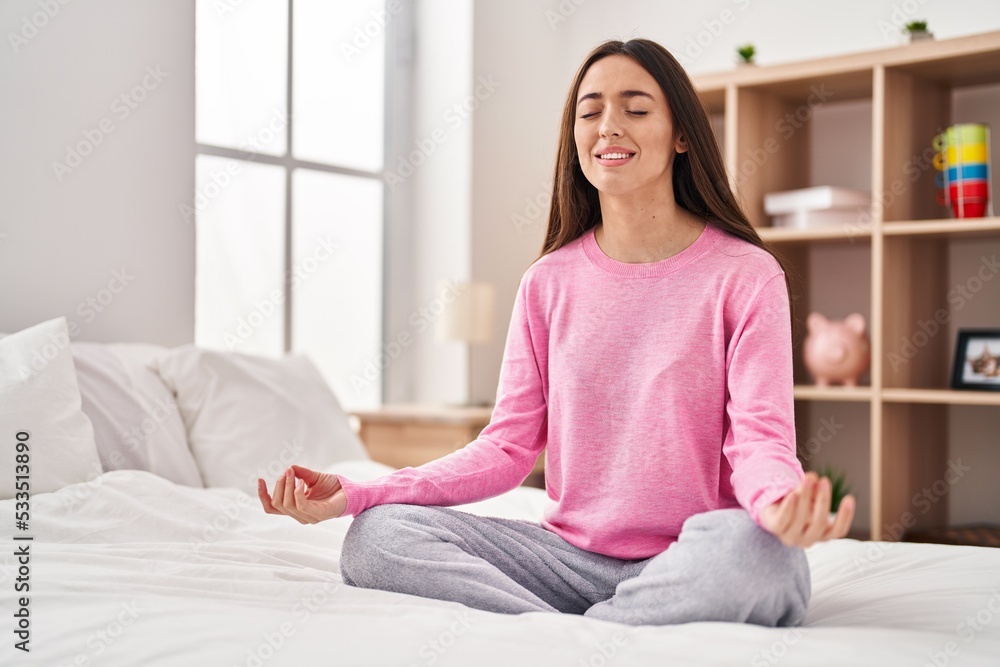 Young beautiful hispanic woman doing yoga exercise sitting on bed at bedroom Young beautiful hispanic woman doing yoga exercise sitting on bed at bedroom