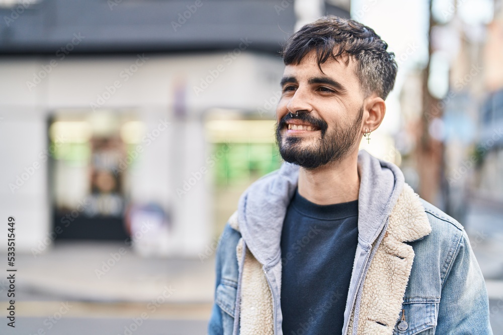 Young hispanic man smiling confident looking to the side at street