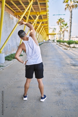 Hispanic man stretching after working out outdoors on a sunny day © Krakenimages.com