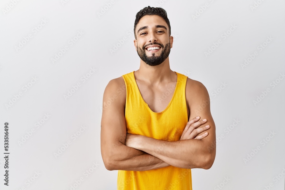 Young handsome man with beard standing over isolated background happy face smiling with crossed arms looking at the camera. positive person. Young handsome man with beard standing over isolated background happy face smiling with crossed arms looking at the camera. positive person.