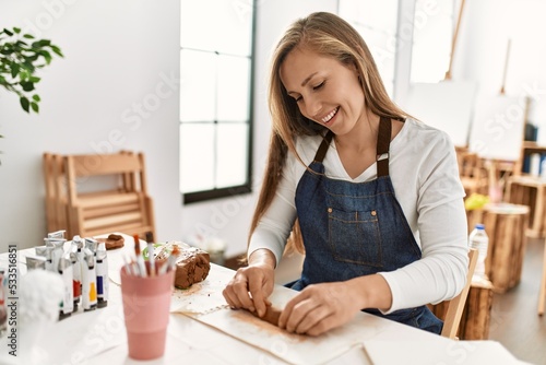 Young caucasian woman smiling confident make handmade clay pot at art studio