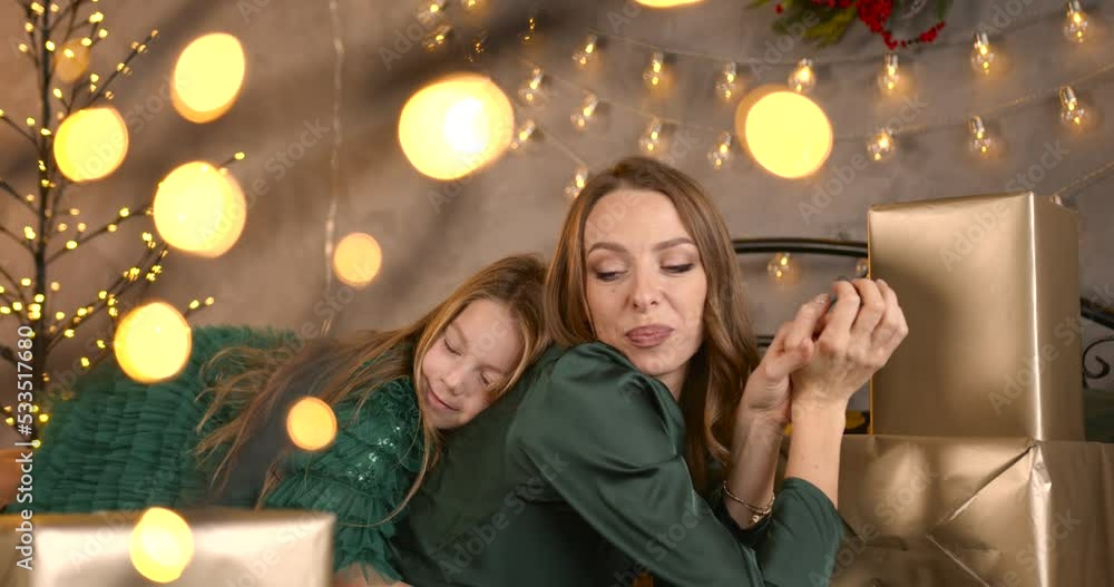 Mother and daughter hugging and posing near xmas tree Mother and daughter hugging and posing near xmas tree