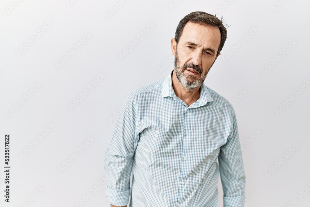 Middle age hispanic man with beard standing over isolated background looking sleepy and tired, exhausted for fatigue and hangover, lazy eyes in the morning. Middle age hispanic man with beard standing over isolated background looking sleepy and tired, exhausted for fatigue and hangover, lazy eyes in the morning.
