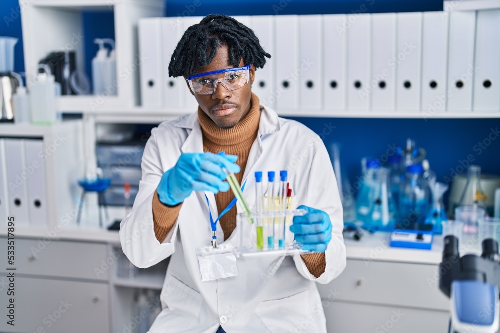 African american man scientist holding test tubes at laboratory