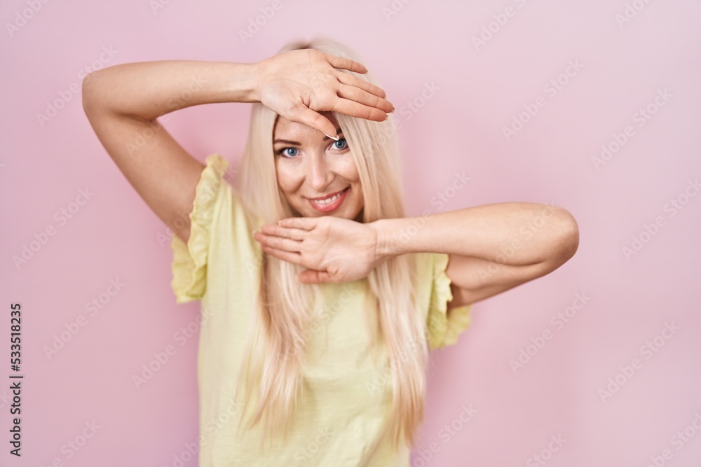 Caucasian woman standing over pink background smiling cheerful playing peek a boo with hands showing face. surprised and exited Caucasian woman standing over pink background smiling cheerful playing peek a boo with hands showing face. surprised and exited