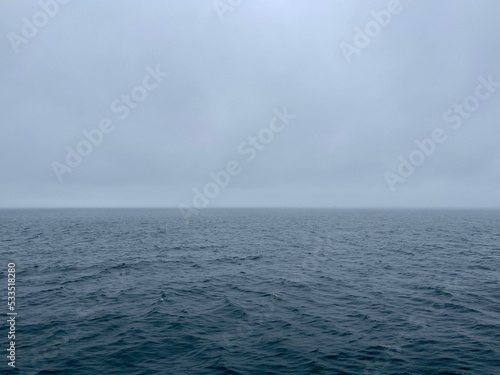 calm ocean with horizon and gray clouds