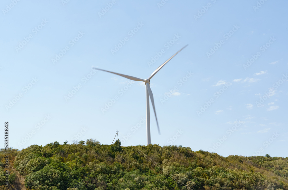 A wind generator standing on a hill generates electricity. A wind generator standing on a hill generates electricity.