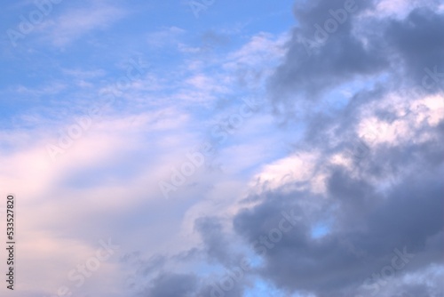 White and dark clouds float towards each other across the blue sky, on the monitor Background Banner Screensaver.