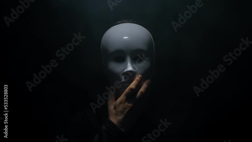 Man in a hoodie takes off his mask. photo