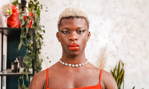 Foto African black transgender model with stylish makeup looking at camera in daytime