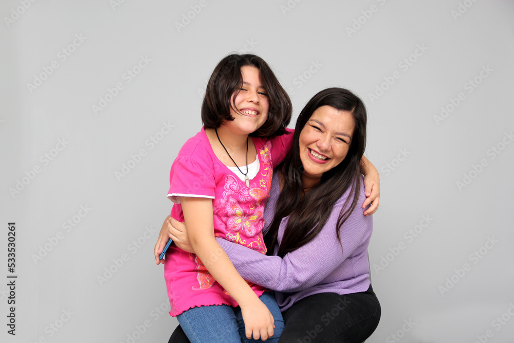 Hispanic Latino mom and daughter play, dance, surprise, enjoy, taking selfies using the cell phone spending quality family time Hispanic Latino mom and daughter play, dance, surprise, enjoy, taking selfies using the cell phone spending quality family time