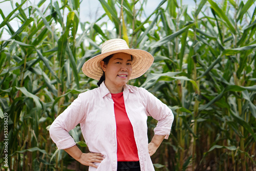 Portrait of Asian woman gardener is at garden  wears hat and puts hands on hips  feels confident  smile and look at camera. Concept   Happy farmer. Agriculture occupation. Organic farming.        