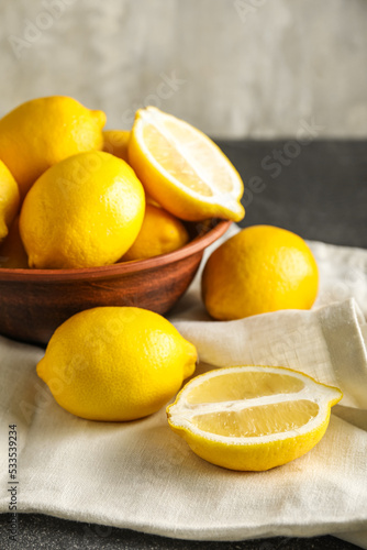Bowl of fresh lemons on table, closeup