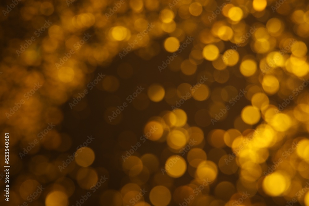 Blurred view of golden glitter on dark background. Bokeh effect Blurred view of golden glitter on dark background. Bokeh effect