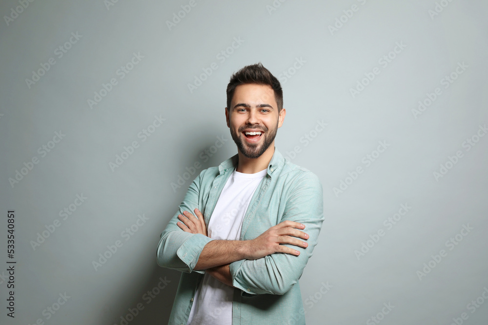 Young man laughing on light grey background. Funny joke Young man laughing on light grey background. Funny joke