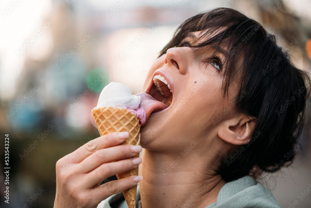 woman eating cream in cafe. Woman ice cream. Dessert. Lips woman. City background. woman eating cream in cafe. Woman ice cream. Dessert. Lips woman. City background.