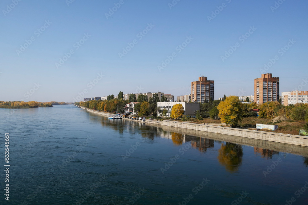View of the city of Ust-Kamenogorsk (kazakhstan). Old residential area. Soviet built multistory apartment buildings. Irtysh river. Autumn. Fall. Yellow trees and Blue sky