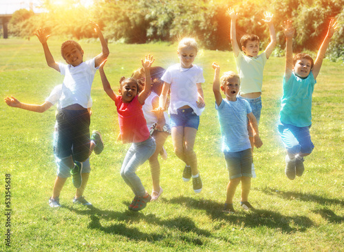 Group of happy children jumping and smiling together in park