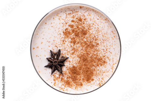 Homemade Eggnog with cinnamon and nutmeg in martini glass isolated on white.