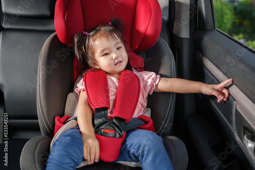 happy toddler girl sitting in car seat