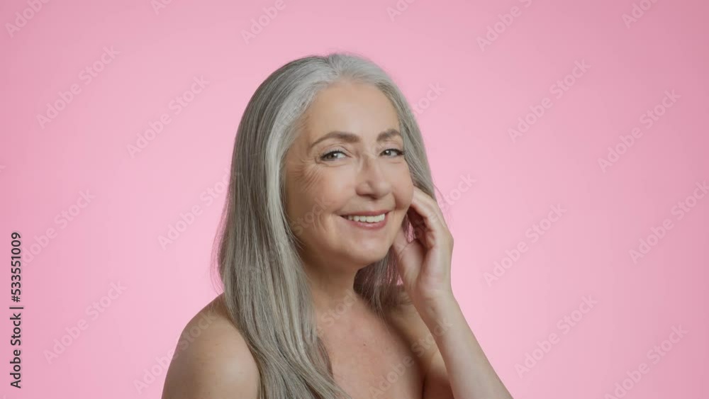 Senior beauty. Gorgeous elderly grey haired woman model smiling to camera, posing with bare shoulders, free space Senior beauty. Gorgeous elderly grey haired woman model smiling to camera, posing with bare shoulders, free space