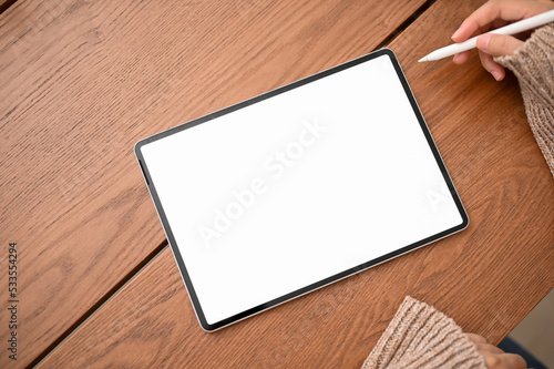 Top view, A female using stylus pen drawing on digital tablet. Tablet white screen mockup