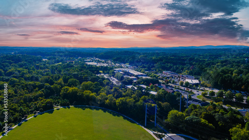 an aerial shot of the vast miles of lush green trees and grass with buildings nestled among the trees and powerful clouds at sunset at Etowah River Park in Canton Georgia USA photo