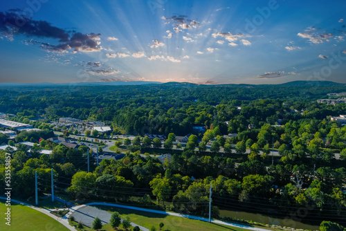 an aerial shot of the vast miles of lush green trees and grass with buildings nestled among the trees and powerful clouds at sunset at Etowah River Park in Canton Georgia USA