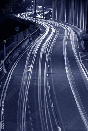 Light trails of traffic on road at night. Transportation background