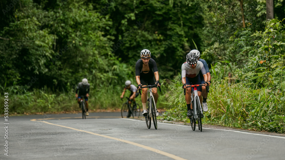 Groups of cyclists riding road bikes in the morning are climbing.