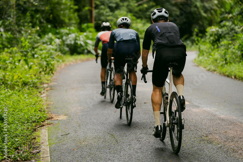 Groups of cyclists riding road bikes in the morning are climbing. © torwaiphoto