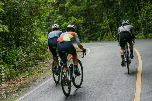 Groups of cyclists riding road bikes in the morning are climbing.