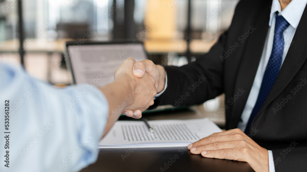Obraz premium Businessman shaking hands with a lawyer or judge After signing the contract and the agreement is complete, Approval of an agreement between business and law, End of the legal case.
