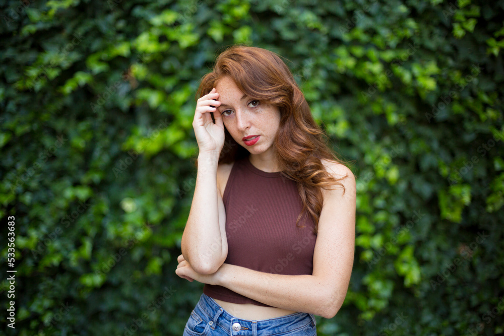 Portrait of a woman with worried expression in a garden Portrait of a woman with worried expression in a garden