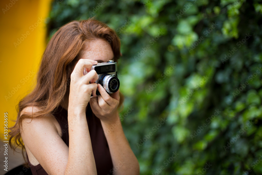 Beauty woman taking photos with a old fashioned camera Beauty woman taking photos with a old fashioned camera