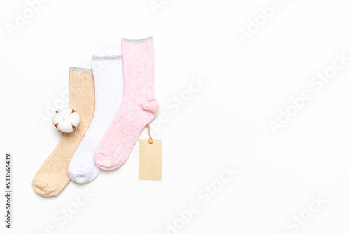 Various modern trendy women's cotton socks set with cotton flowers and price tags on white background. Fashionable socks store. Socks shopping, sale, merchandise, advertisement concept. Copy space