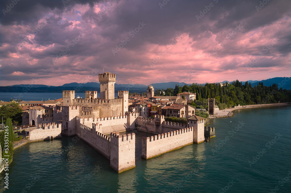 Pink clouds over Scaligero Castle aerial view. Scaligero Castle at sunrise, Lake Garda, Italy.