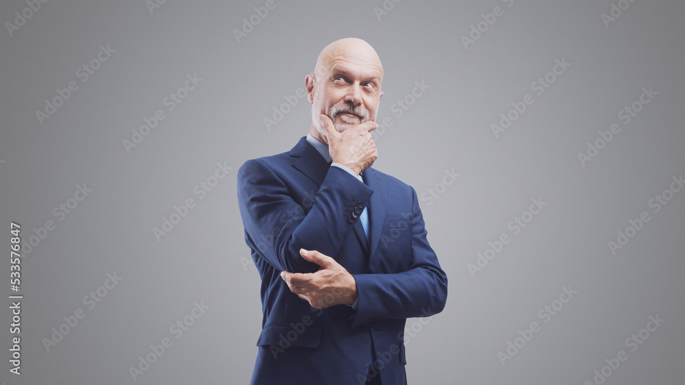 Corporate businessman thinking with hand on chin Corporate businessman thinking with hand on chin